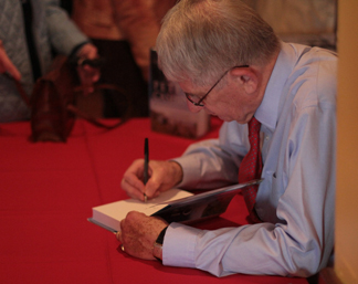 Edward Roberts signs a copy of Peter Cashin: My Fight for Newfoundland for a guest.