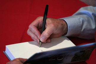 Edward Roberts signs a copy of Peter Cashin: My Fight for Newfoundland for a guest